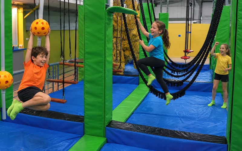 Dziesięciolatki rywalizują na torze ninja w Jumpout (obraz wygenerowany przez AI)